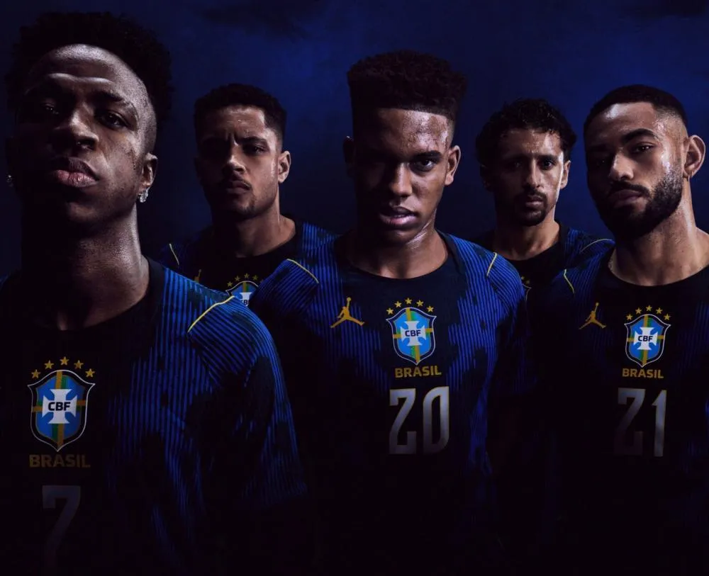 Sele&ccedil;&atilde;o Brasileira Publicado em 12/03/2026 &agrave;s 19h45. CBF inova e lan&ccedil;a novo uniforme 2 da Sele&ccedil;&atilde;o Brasileira; confira O material &eacute; produzido com 100% de res&iacute;duos t&ecirc;xteis e possui zonas de malha que favorecem a circula&ccedil;&atilde;o de ar entre o corpo e o tecido Neison Cerqueira Twitter Whatsapp Foto: Divulga&ccedil;&atilde;o/Jordan/Nike A Sele&ccedil;&atilde;o Brasileira apresentou nesta quinta-feira (12), em S&atilde;o Paulo, o novo segundo uniforme em parceria com a Jordan Brand. A iniciativa marca um momento hist&oacute;rico: &eacute; a primeira vez que o tradicional logo Jumpman estampa o uniforme de uma sele&ccedil;&atilde;o nacional de futebol. Veja a nova camisa no final da reportagem. O novo kit foi desenvolvido para unir desempenho e identidade cultural. Inspirado em elementos do Brasil e na est&eacute;tica da marca ligada ao &iacute;dolo do basquete Michael Jordan, o uniforme combina os tradicionais tons amarelo e azul com a ic&ocirc;nica estampa &ldquo;Elephant Print&rdquo;, criada por Tinker Hatfield no modelo Air Jordan 3, lan&ccedil;ado em 1988. A estreia do novo uniforme j&aacute; tem data marcada: ser&aacute; no amistoso entre Brasil e Fran&ccedil;a, no dia 26 de mar&ccedil;o, no Gillette Stadium, em Boston, nos Estados Unidos, &agrave;s 17h (hor&aacute;rio de Bras&iacute;lia). As primeiras pe&ccedil;as da cole&ccedil;&atilde;o estar&atilde;o dispon&iacute;veis no Nike App e em nike.com.br/jordan a partir das 21h (de Bras&iacute;lia) desta quinta-feira (12). Nesta sexta (13), estar&atilde;o dispon&iacute;veis em todo o mercado brasileiro. Tecnologia e desempenho O uniforme foi desenvolvido com a tecnologia Aero-FIT, voltada para melhorar a respirabilidade e o conforto dos atletas em campo. O material &eacute; produzido a partir de 100% de res&iacute;duos t&ecirc;xteis e possui zonas de malha que favorecem a circula&ccedil;&atilde;o de ar entre o corpo e o tecido. Segundo os desenvolvedores, o modelo &eacute; 11% mais leve e pode ser at&eacute; 238% mais respir&aacute;vel, ajudando os jogadores a manterem o desempenho mesmo em condi&ccedil;&otilde;es de alta intensidade. Parceria celebrada O presidente da CBF, Samir Xaud, destacou o simbolismo da parceria entre a Sele&ccedil;&atilde;o e a marca global. &ldquo;Este lan&ccedil;amento simboliza a uni&atilde;o entre duas refer&ecirc;ncias globais que compartilham ousadia, inova&ccedil;&atilde;o e paix&atilde;o pelo esporte. Ver o Jumpman em nosso uniforme refor&ccedil;a a pot&ecirc;ncia cultural do futebol brasileiro e a capacidade do Brasil de inspirar o mundo. Estamos orgulhosos desse momento e confiantes de que este manto representar&aacute;, dentro e fora de campo, a energia e a grandeza da nossa Sele&ccedil;&atilde;o&rdquo;, afirmou. O atacante Vinicius Jr. tamb&eacute;m celebrou a novidade e ressaltou o impacto da colabora&ccedil;&atilde;o para os jovens brasileiros. &ldquo;Para cada crian&ccedil;a no Brasil que sonha com uma bola nos p&eacute;s, essa parceria significa algo enorme. Jordan Brand e a nossa Sele&ccedil;&atilde;o se unirem &eacute; mais do que futebol &ndash; &eacute; cultura e grandeza juntas. Quando o Jumpman aparece ao lado das nossas cores, isso mostra ao mundo a criatividade, a paix&atilde;o e a energia que tornam o Brasil especial. Isso inspira a nova gera&ccedil;&atilde;o a jogar com estilo, liberdade e orgulho toda vez que entramos em campo&rdquo;, disse. Cole&ccedil;&atilde;o completa Al&eacute;m do uniforme reserva, a parceria inclui uma linha de roupas de treino com tecnologia Aero-FIT e uma vers&atilde;o especial da chuteira Tiempo, que tamb&eacute;m traz o logo Jumpman e a estampa caracter&iacute;stica da Jordan Brand. A cole&ccedil;&atilde;o busca refor&ccedil;ar a conex&atilde;o entre esporte, cultura e performance, posicionando o Brasil como protagonista em mais uma colabora&ccedil;&atilde;o global no futebol. bahia-ba Confira como ficou a nova camisa da Sele&ccedil;&atilde;o Brasileira Atletas da Sele&ccedil;&atilde;o Brasileira s&atilde;o os modelos na apresenta&ccedil;&atilde;o da nova camisa. Foto: Divulga&ccedil;&atilde;o/Jordan/Nike