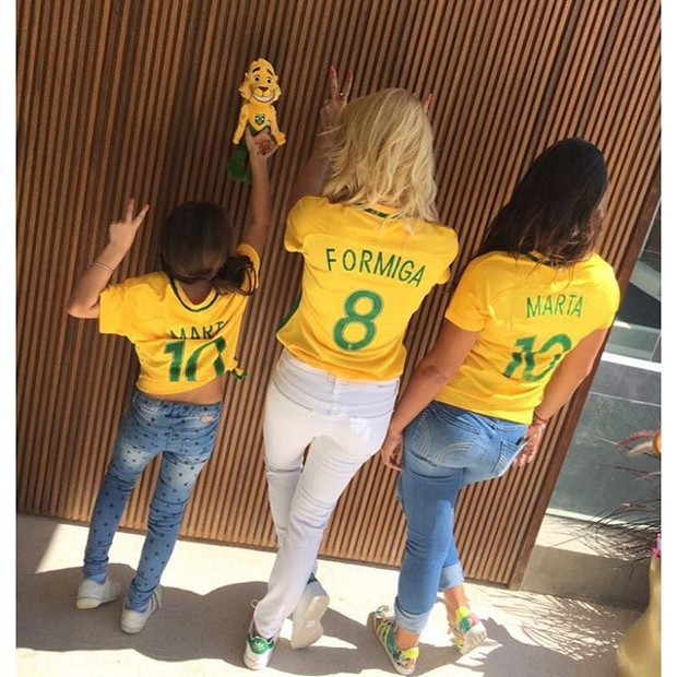 Flávia Alessandra posa com filhas vestindo camisas da seleção feminina