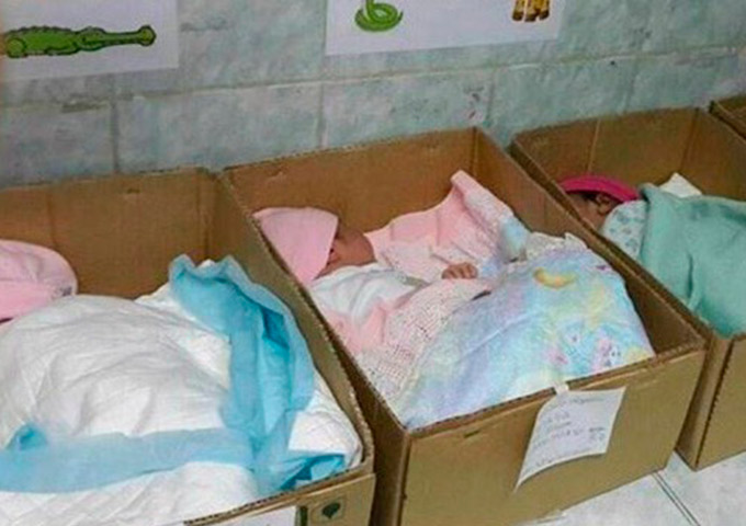Recém-nascidos dormem em caixas de papelão em hospital 