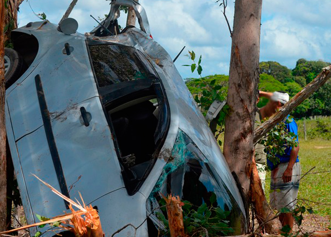 Carro fica preso entre árvores após motorista desviar de buraco
