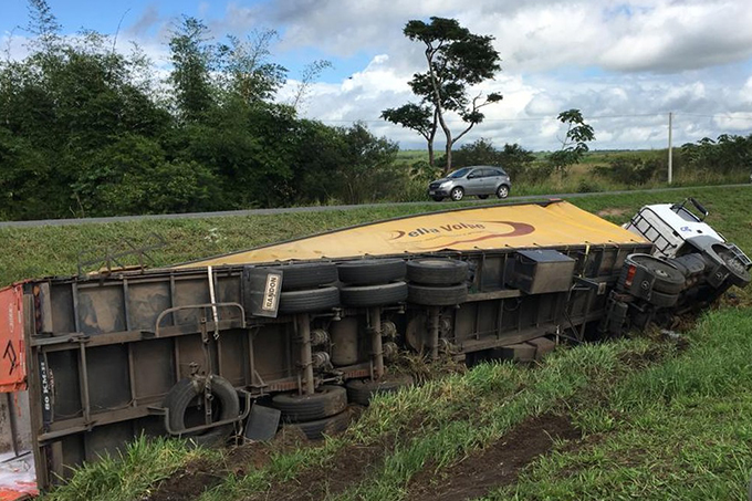 Carreta tomba e cai no canteiro central na BR-324