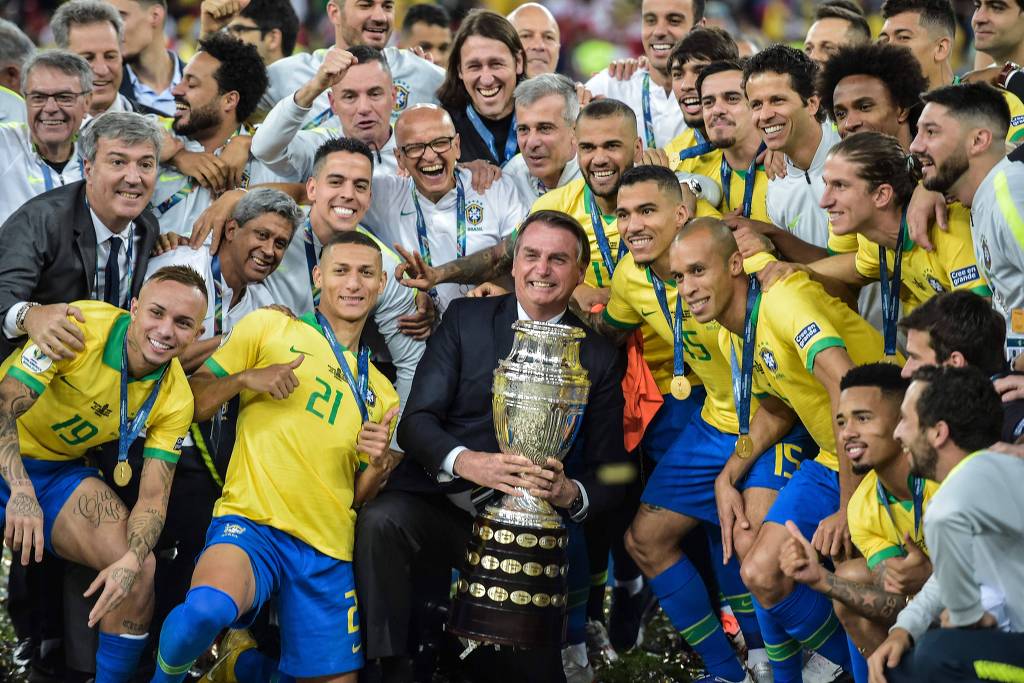Bolsonaro tira foto com taça e ouve 'mito' de jogadores do Brasil