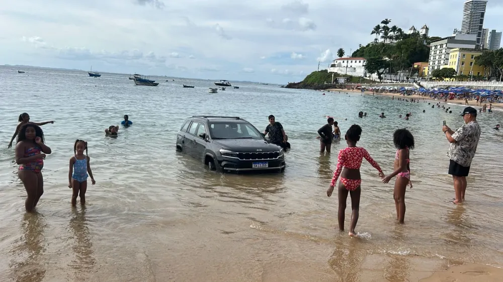 Carro atola na praia do Porto da Barra e fica parcialmente submerso